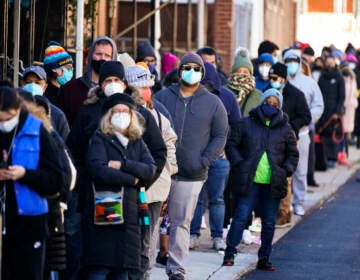 City residents wait in a line extending around the block to receive free at-home rapid COVID-19 test kits in Philadelphia