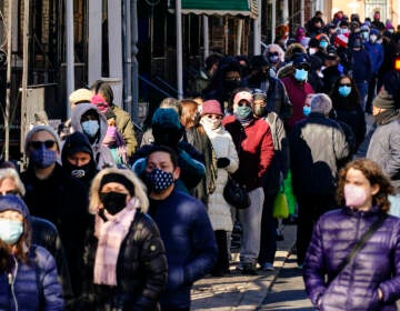 City residents wait in a line extending around the block to receive free at-home rapid COVID-19 test kits in Philadelphia