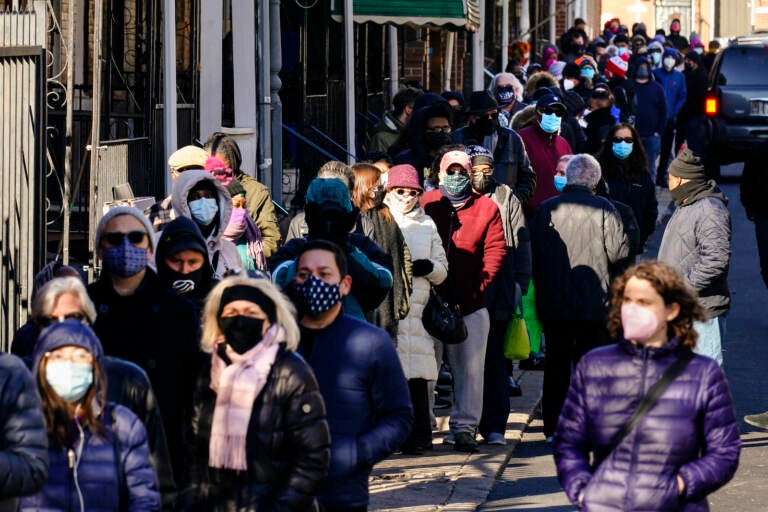 City residents wait in a line extending around the block to receive free at-home rapid COVID-19 test kits in Philadelphia
