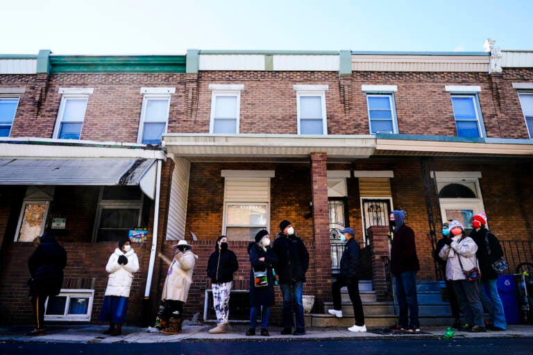 City residents wait in a line extending around the block to receive free at-home rapid COVID-19 test kits in Philadelphia