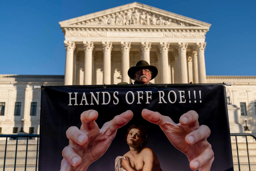 Stephen Parlato holds a sign that reads "Hands Off Roe!!!" outside the Supreme Court