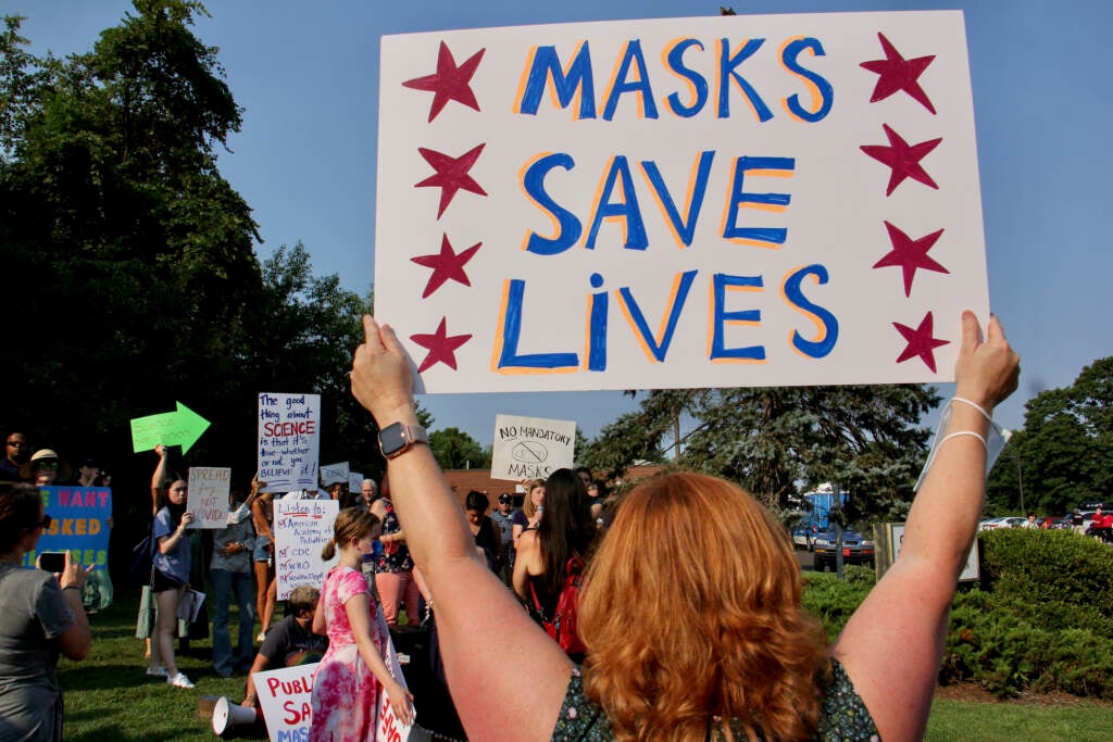 Parents gather outside a Central Bucks school board meeting to protest or defend the board’s decision to open schools in the fall without requiring protective face mask