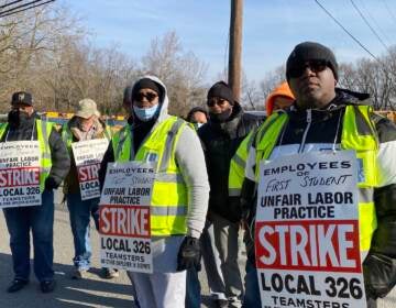 Striking bus drivers with Teamsters Local 326 stand outside the First Student bus yard