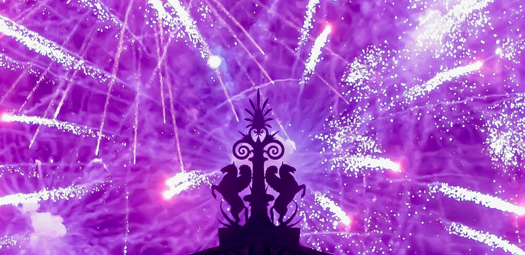 Fireworks explode in the background behind a gargoyle atop of the central portico of the Philadelphia Museum of Art