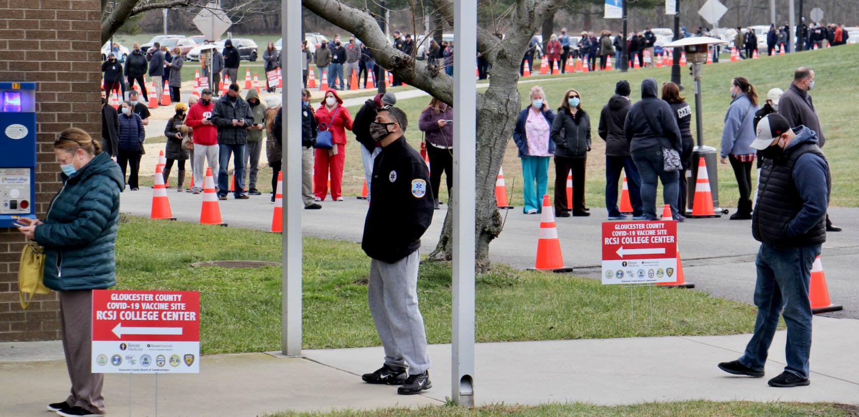 Hundreds of people, mostly first responders and medical workers, line up at Rowan College of South Jersey in Sewell, N.J.,to be vaccinated against COVID-19.