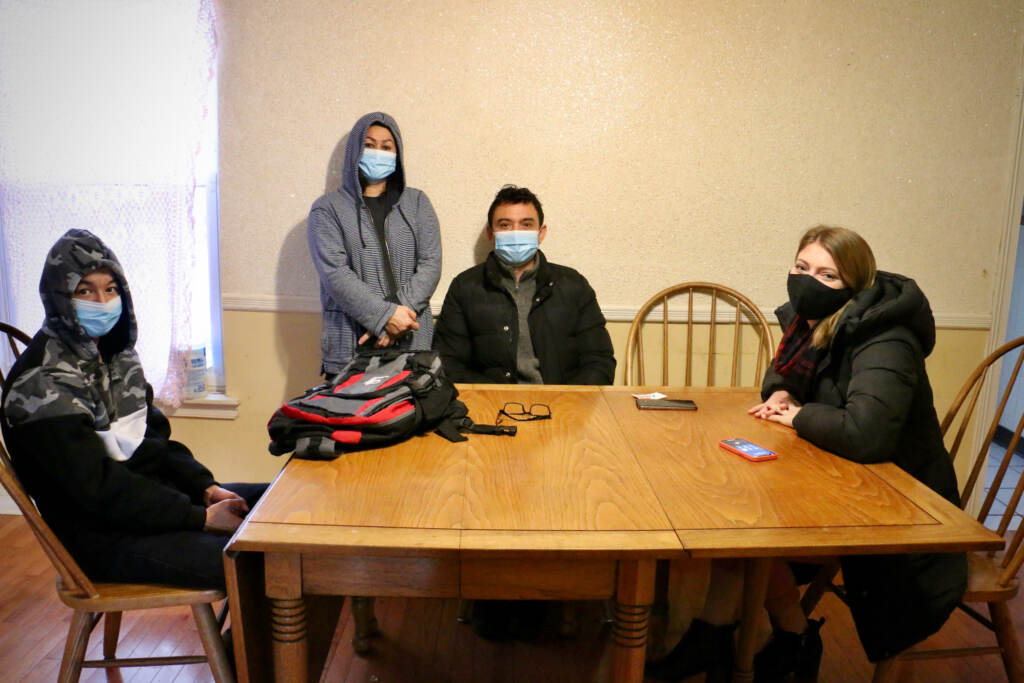 (From left) Ali Wahaj Mosakhil, his mother, Sakina and father Esmatullah, meet with Michelle Ferguson at a kitchen table