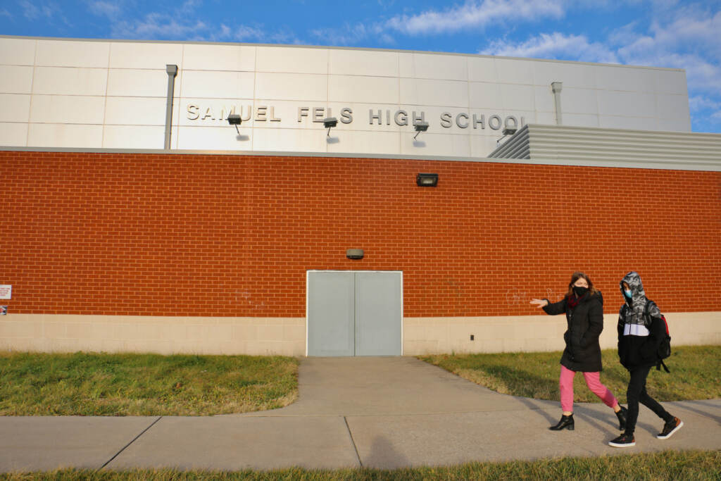 Michelle Ferguson walks with Ali Wahaj Mosakhil outside of a school