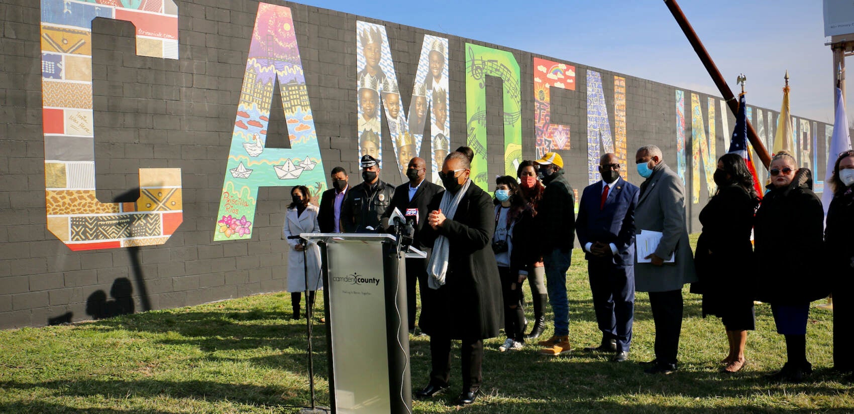 Camden officials gather at the intersection of 16th Street and Admiral Wilson Boulevard to dedicate the ''Camden Invincibile'' mural. (Emma Lee/WHYY)
