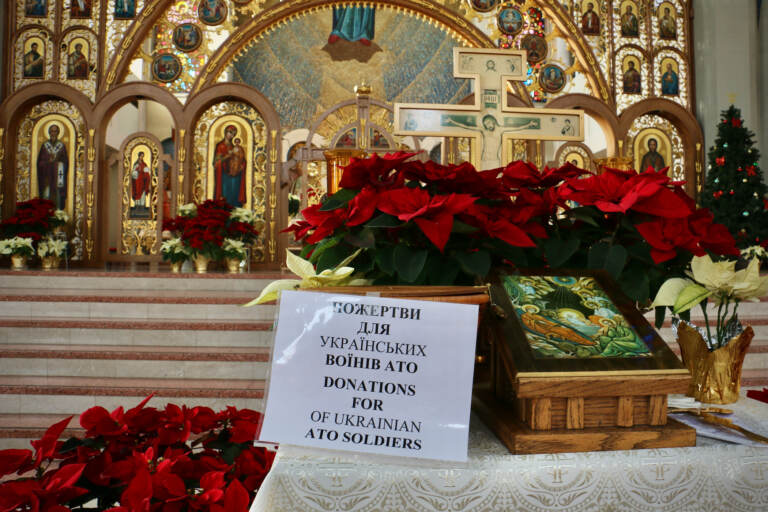 A collection box near the altar at the Cathedral of the Immaculate Conception urges donations for Ukrainian soldiers fighting the Russians. (Emma Lee/WHYY)