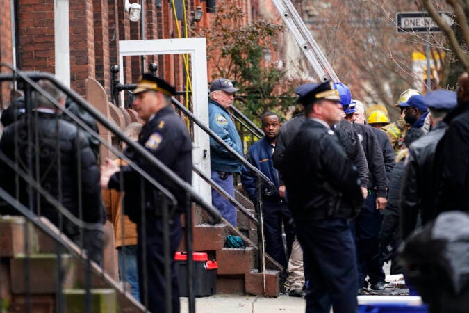 Philadelphia firefighters and police work at the scene of a deadly fire