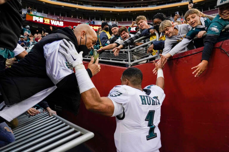 A hand railing collapses and fans fall onto Philadelphia Eagles quarterback Jalen Hurts (1) following the end of an NFL football game, Sunday, Jan. 2, 2022, in Landover, Md. Philadelphia won 20-16. (AP Photo/Alex Brandon)