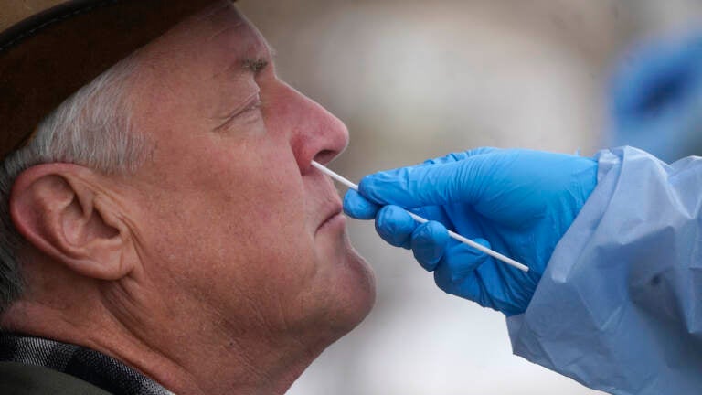 A member of the Salt Lake County Health Department COVID-19 testing staff performs a test on Gary Mackelprang outside the Salt Lake County Health Department Tuesday, Jan. 4, 2022, in Salt Lake City
