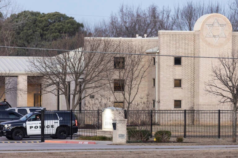 Police stage in front of the Congregation Beth Israel synagogue, Sunday, Jan. 16, 2022, in Colleyville, Texas. A man held hostages for more than 10 hours Saturday inside the temple. The hostages were able to escape and the hostage taker was killed. (AP Photo/Brandon Wade)