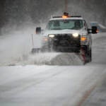 A snowplow clears a main road during a winter storm in Southwest Roanoke City on Sunday, Jan. 16, 2022, in Roanoke, Va. (AP Photo/Don Petersen)