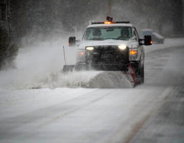 A snowplow clears a main road during a winter storm in Southwest Roanoke City on Sunday, Jan. 16, 2022, in Roanoke, Va. (AP Photo/Don Petersen)
