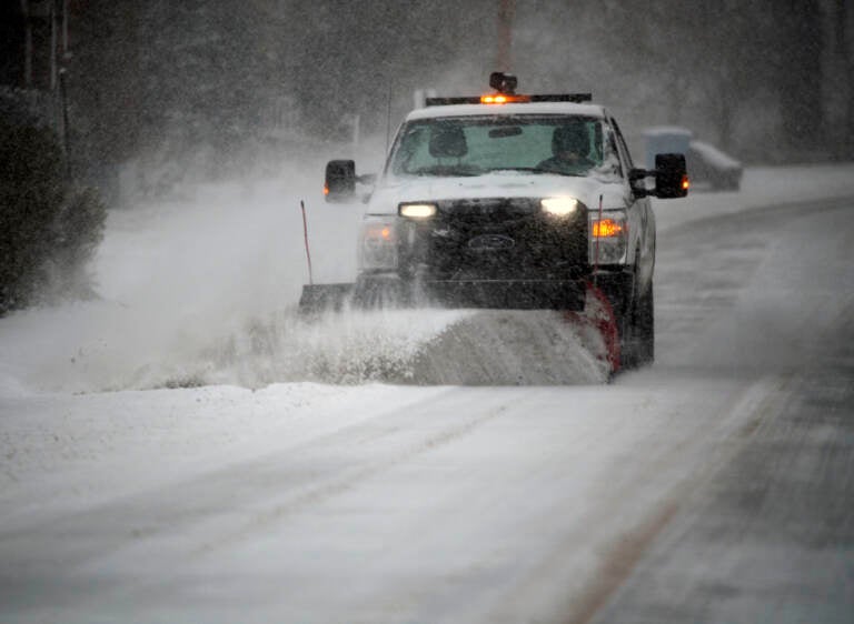 A snowplow clears a main road during a winter storm in Southwest Roanoke City on Sunday, Jan. 16, 2022, in Roanoke, Va. (AP Photo/Don Petersen)