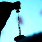 Silhouette of a COVID-19 vaccine being prepared.