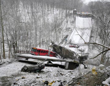 A Port Authority bus that was on a bridge when it collapsed Friday Jan. 28, 2002, is visible in Pittsburgh’s East End. When the bridge collapsed, rescuers rappeled nearly 150 feet while others formed a human chain to help rescue multiple people from the dangling bus. (AP Photo/Gene J. Puskar)