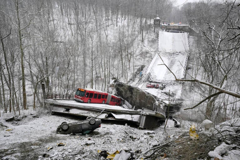 A Port Authority bus that was on a bridge when it collapsed Friday Jan. 28, 2002, is visible in Pittsburgh’s East End. When the bridge collapsed, rescuers rappeled nearly 150 feet while others formed a human chain to help rescue multiple people from the dangling bus. (AP Photo/Gene J. Puskar)