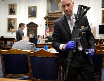 Kenosha Protest Shootings File photo: Kenosha Police Department Detective Martin Howard, right, picks up the weapon Kyle Rittenhouse used on Aug. 25, 2020, during Rittenhouse's trial at the Kenosha County Courthouse in Kenosha, Wis., on Nov. 8, 2021. A Wisconsin judge on Friday, Jan. 28, 2022, approved an agreement by lawyers to destroy the assault-style rifle that Rittenhouse used to shoot three people during a 2020 street protest