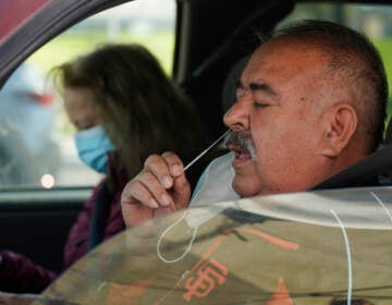 Jose Alfrtedo De la Cruz and his wife, Rogelia, self-test for COVID-19 at a No Cost COVID-19 Drive-Through event provided the GUARDaHEART Foundation for the City of Whittier community and the surrounding areas at the Guirado Park in Whittier, Calif., on Tuesday, Jan. 25, 2022. California is showing signs that it may have turned the corner on the latest omicron wave of the coronavirus pandemic, with cases falling and hospitalizations short of the overwhelming deluge that officials had predicted just weeks ago. (AP Photo/Damian Dovarganes)