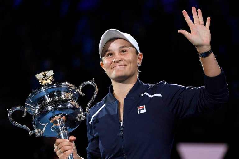 Ash Barty of Australia waves as she holds the Daphne Akhurst Memorial Cup after defeating Danielle Collins of the U.S., in the women's singles final at the Australian Open tennis championships in Saturday, Jan. 29, 2022, in Melbourne, Australia