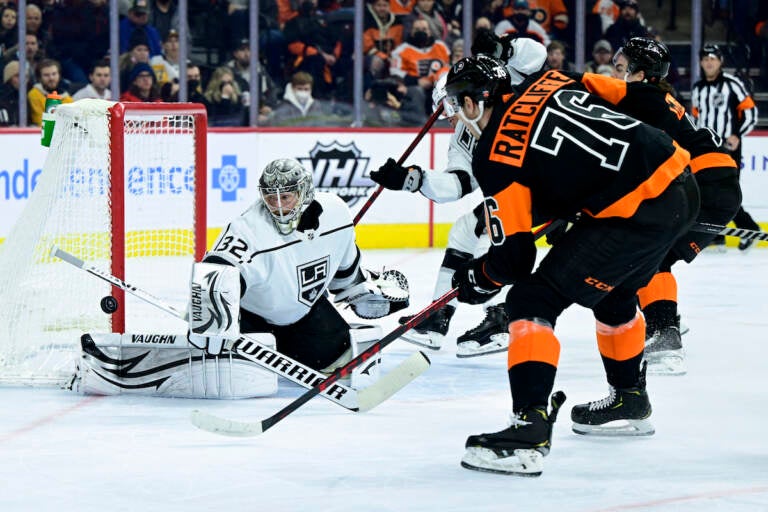 Los Angeles Kings goaltender Jonathan Quick, left, makes a save on a shot from Philadelphia Flyers' Isaac Ratcliffe (76) during the second period of an NHL hockey game, Saturday, Jan. 29, 2022, in Philadelphia. (AP Photo/Derik Hamilton)