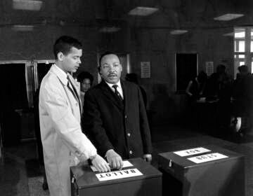 A photo of Julian Bond and Dr. Martin Luther King Jr. casting their ballots to fill Bond's vacant seat in the U.S. House of Representatives in Atlanta, Ga., on Feb. 23, 1966.  (AP Photo)