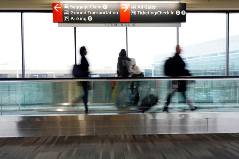 Travelers walk to their gates at the Philadelphia International Airport