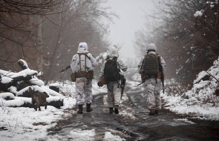 FILE - Ukrainian soldiers walks at the line of separation from pro-Russian rebels near Katerinivka, Donetsk region, Ukraine, Tuesday, Dec 7, 2021. (AP Photo/Andriy Dubchak)