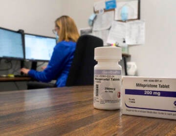 A nurse practitioner works in an office at a Planned Parenthood clinic as containers of the medication used to end an early pregnancy sits on a table nearby