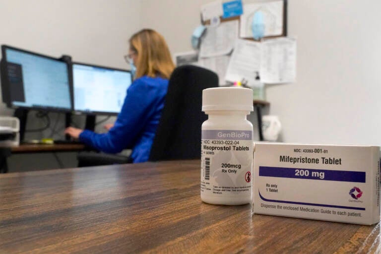 A nurse practitioner works in an office at a Planned Parenthood clinic as containers of the medication used to end an early pregnancy sits on a table nearby