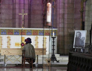 Mpho Tutu, sits with the coffin of her father Anglican Archbishop Emeritus Desmond Tutu during his funeral at the St. George's Cathedral in Cape Town, South Africa, Saturday, Jan. 1, 2022. Tutu, the Nobel Peace Prize-winning activist for racial equality and LGBT rights died Sunday at the age of 90. (Nic Bothma/Pool Photo via AP)