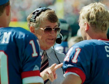 FILE - New York Giants head coach Dan Reeves gives some instructions to his starting quarterback Phil Simms during the third quarter of their game against the Tampa Bay Buccaneers at Giants Stadium in East Rutherford, N.J. on Sunday, Sept. 12, 1993.  Reeves, who won a Super Bowl as a player with the Dallas Cowboys but was best known for a long coaching career highlighted by four more appearances in the title game with the Denver Broncos and Atlanta Falcons, died Saturday, Jan. 1, 2022.  (AP Photo/Mark Lennihan, File)