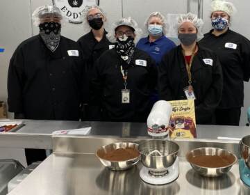 Workers pose for a photo inside First State Compassion's new kitchen