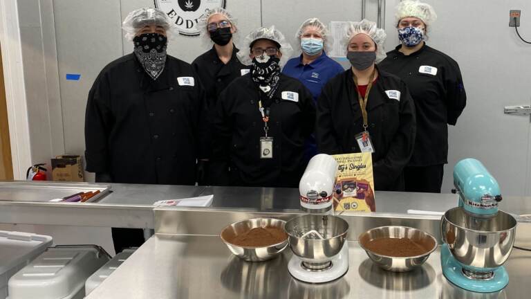 Workers pose for a photo inside First State Compassion's new kitchen