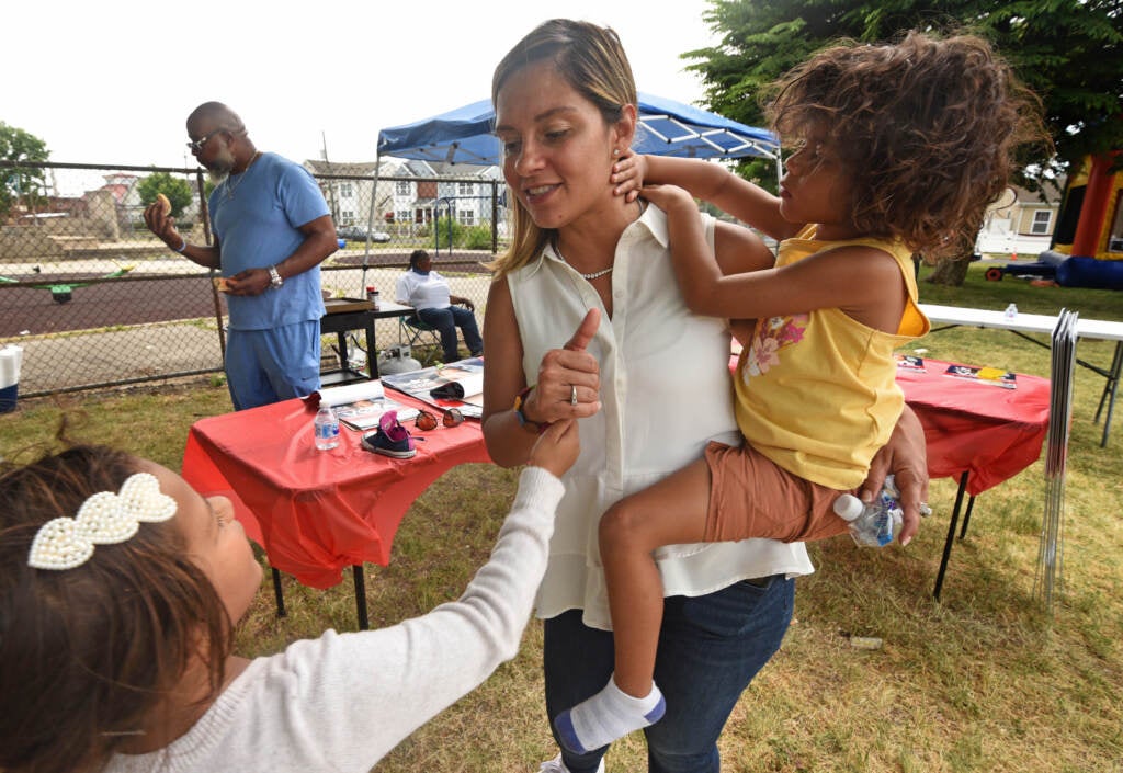 Felisha Reyes-Morton holds her child Saige while talking with her other child, Ruby