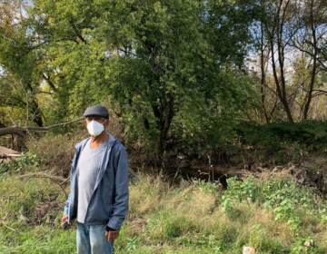 Resident Leo Brundage stands in front of the flood-prone creek behind his house (Megan Ruggles)