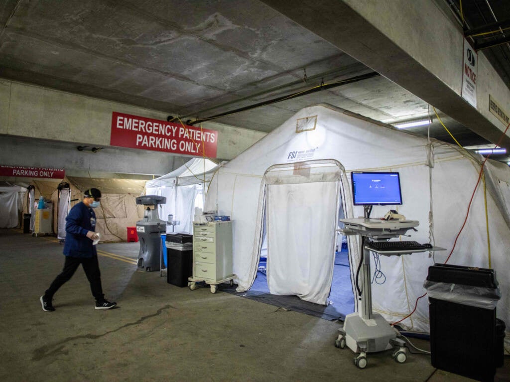 A nurse walks inside a temporary Emergency Room, built into a parking garage