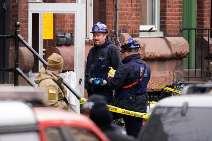 Investigators gather near the entrance to the building