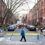 A passer-by looks over the barricade on the street of Wednesday's deadly fire