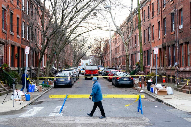 A passer-by looks over the barricade on the street of Wednesday's deadly fire
