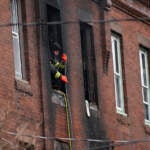 A Philadelphia firefighter works at the scene of a deadly rowhouse fire
