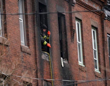 A Philadelphia firefighter works at the scene of a deadly rowhouse fire