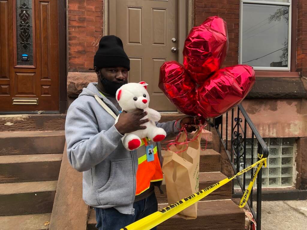 Marty Edwards holds up a teddy bear and balloons