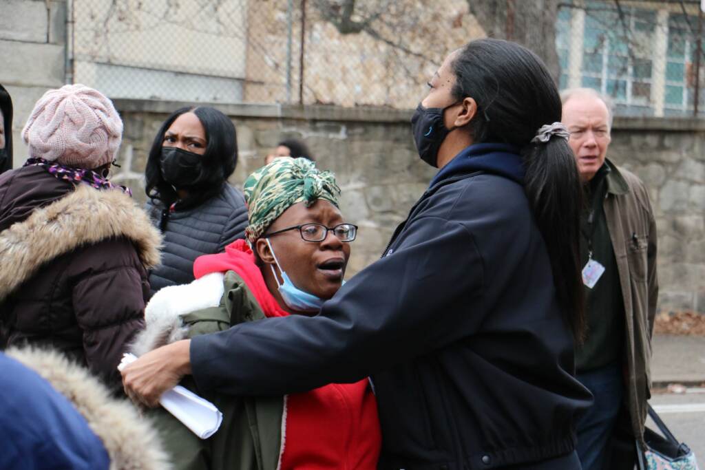 A woman is consoled at the corner of 23rd and Poplar streets