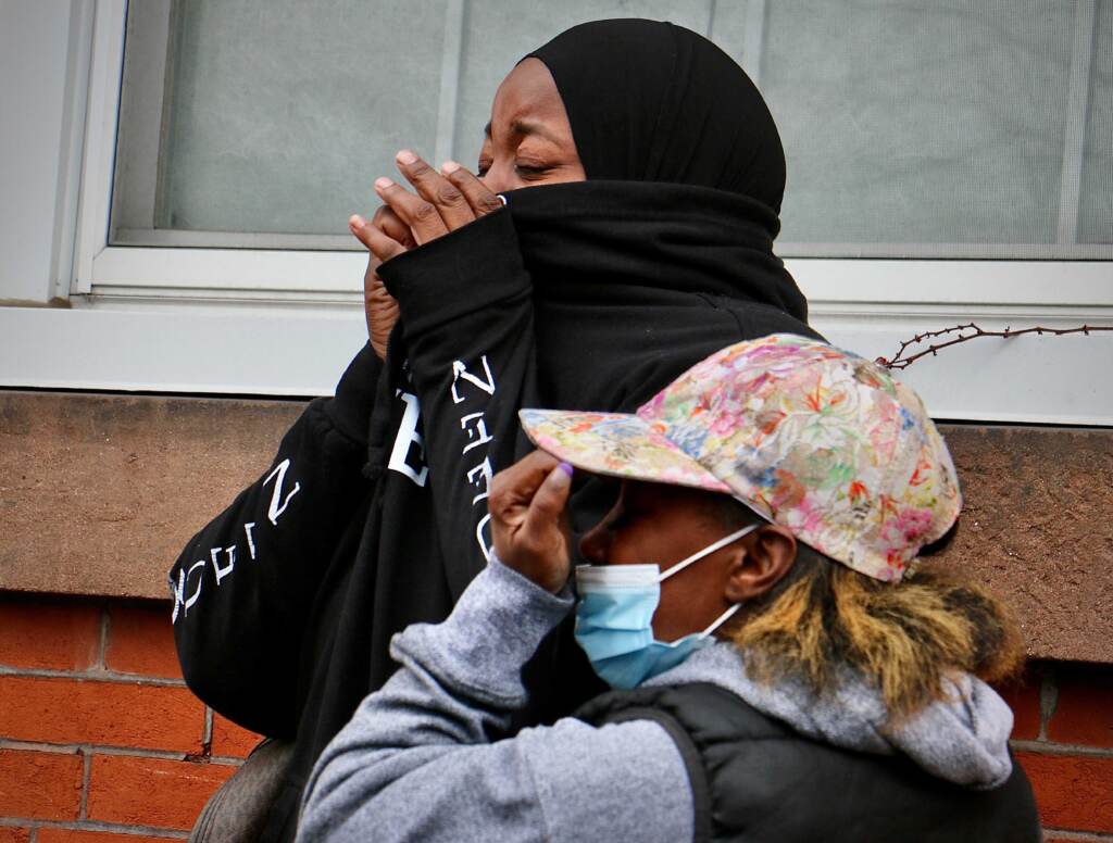 Women weep near the scene of a house fire