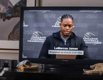 Actor Stephan James portraying football player LeMarcus James giving a press conference on TV in the movie National Champions