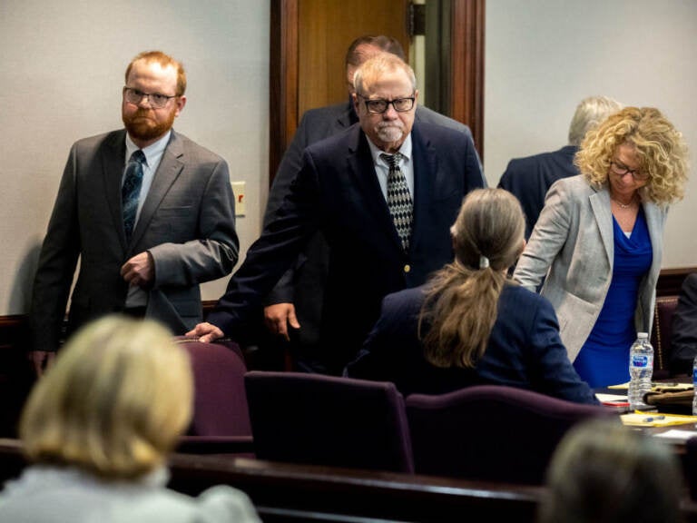 Greg McMichael, center, and his son, Travis McMichael, left, look at family members seated in the gallery when they walk into the courtroom for the reading of the jury’s verdict for themselves and a neighbor, William “Roddie” Bryan in the Glynn County Courthouse on Nov. 24, 2021 in Brunswick, Ga. The three men were charged with the fatal shooting of 25-year-old Ahmaud Arbery in 2020. Greg McMichael, center, and his son, Travis McMichael, left, look at family members seated in the gallery when they walk into the courtroom