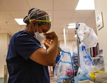 A medical worker puts on a mask before entering a negative pressure room with a Covid-19 patient in the ICU ward at UMass Memorial Medical Center in Worcester, Mass. on January 4, 2022. (Joseph Prezioso/AFP via Getty Images)